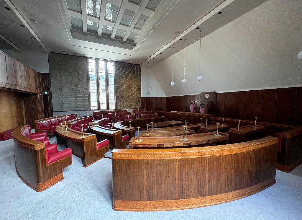 The Council Chamber from the dais, with the curved wooden desks and red seats